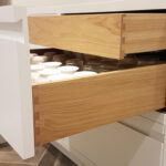 A kitchen with a drawer full of glasses.